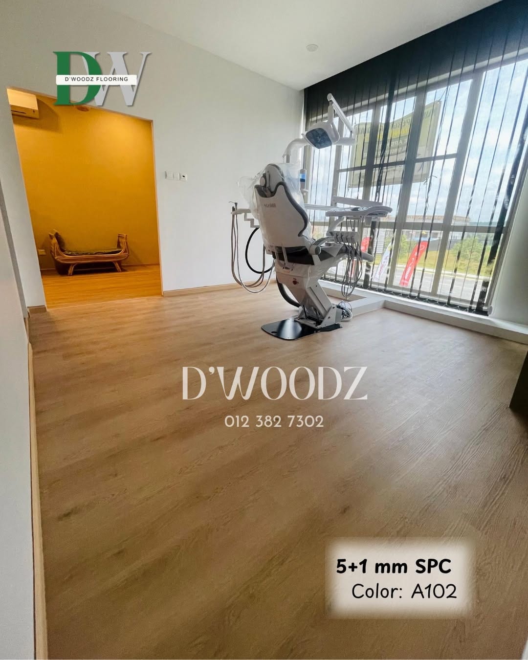A dental treatment room with a dental chair on an oak-toned plank floor, an orange wall beyond and full-height windows; the D'Woodz watermark and product label in frame.