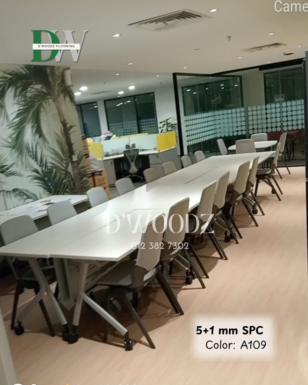 A long white boardroom table with grey chairs on a pale oak-toned plank floor, glass partitions behind; the D'Woodz watermark and product label in frame.