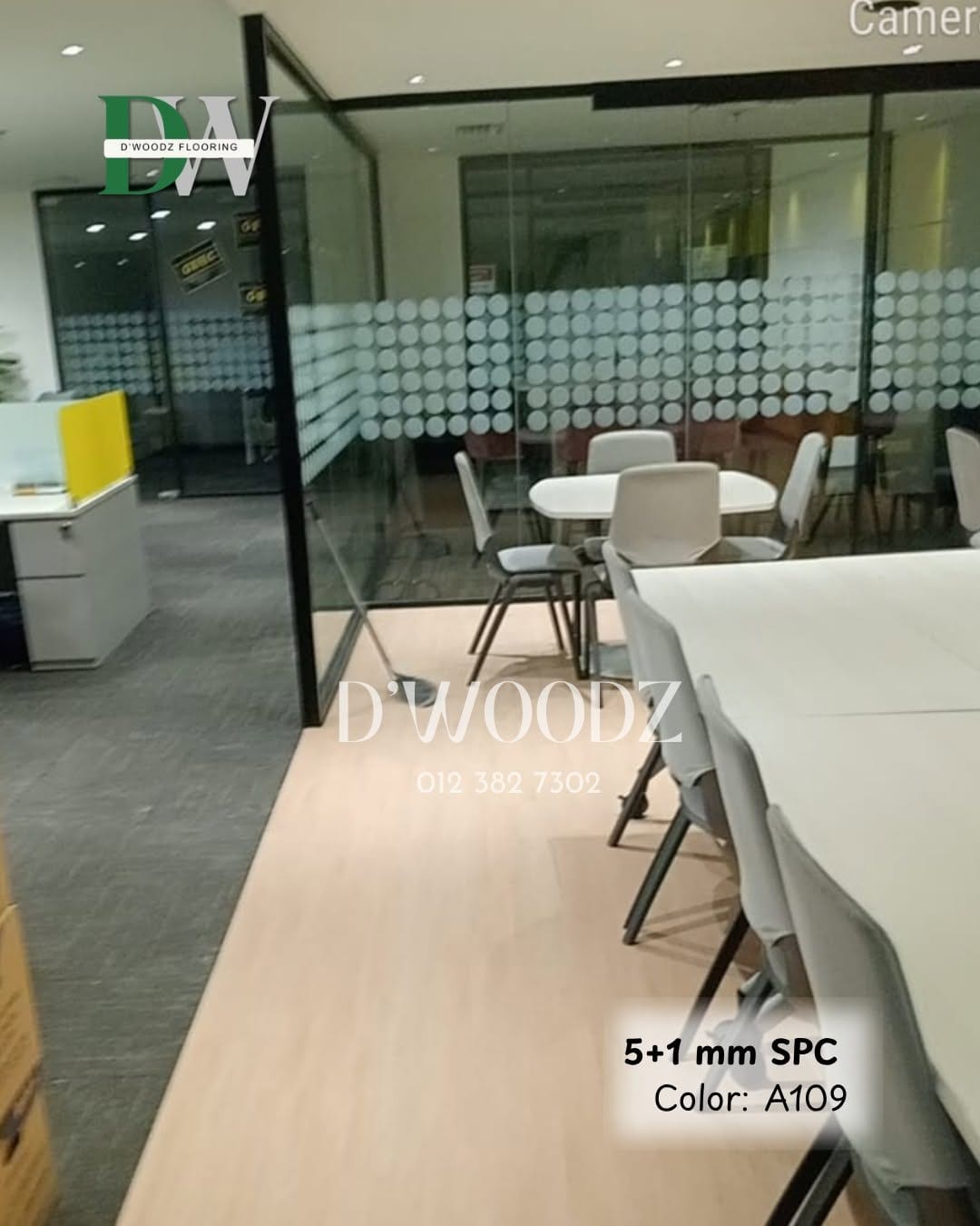 An office with frosted glass partitions, a white meeting table and stools on a pale oak-toned plank floor; the D'Woodz watermark and product label in frame.